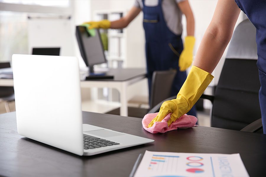 Janitorial Service Insurance - Janitors Cleaning Up a Desk Area After Business Hours