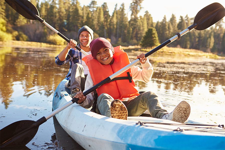 Blog - Father And Son Rowing Kayak On Lake