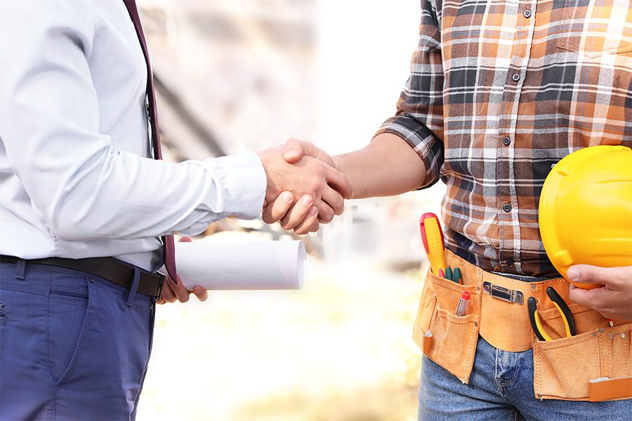 Specialized Business Insurance - Male Architect and Builder Shaking Hands Outdoors at a Construction Site